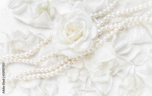 Beautiful white rose and pearl necklace on a background of petals. Ideal for greeting cards for wedding, birthday, Valentine's Day, Mother's Day