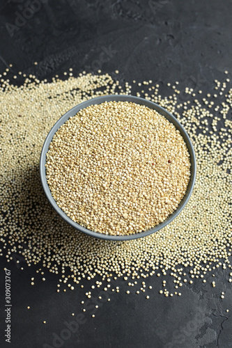 Organic quinoa seeds grain in bowl on dark background, top view