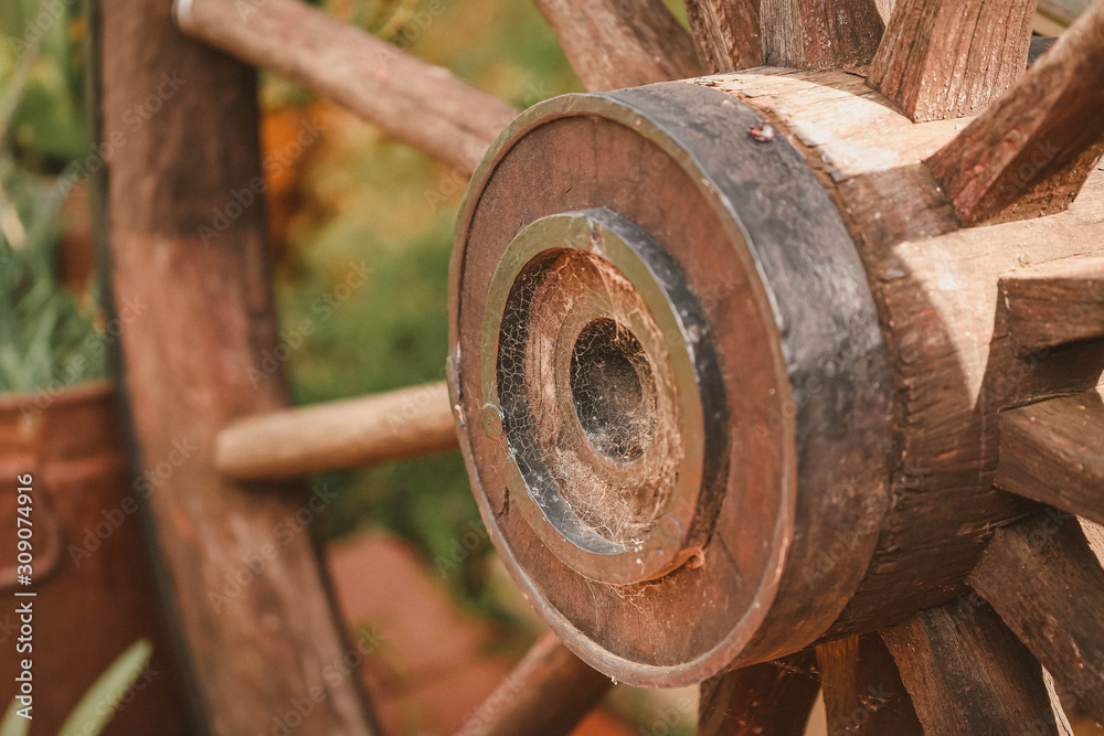 Close up center of rustic wagon wheel with cobwebs made of metal and wood Close up center of rustic wagon wheel with cobwebs made of metal and wood