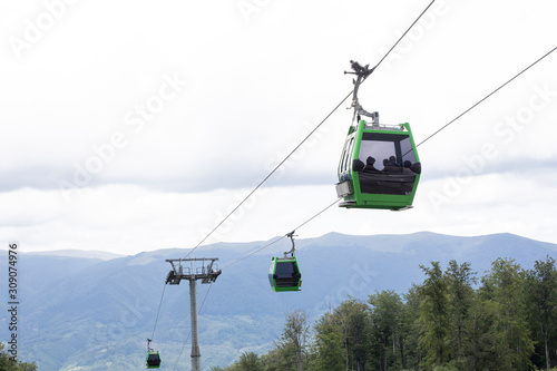 Mountain Cable car / gondola in the summer. Mountains in the background and cloudy sky