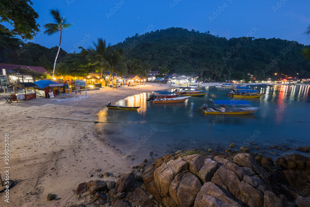 Pulau Perhentian, Terengganu - August 14th, 2018  : Beautiful view of small Perhentian Island with multiple boats during blue hour. Image contains noise and soft focus