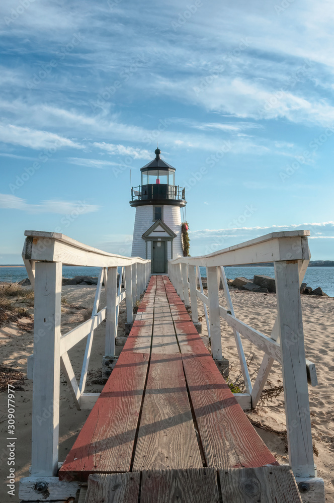 Brand Point Lighthouse with its long footbridge , located on Nantucket Island in Massachusetts, decorated for the holidays with a Christmas wreath and crossed oars.