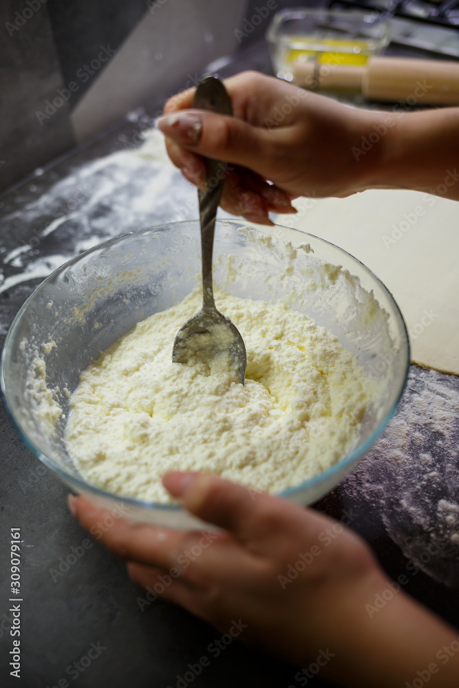 Baking domestic rolls with cheese. Putting cheese on dough for rolls