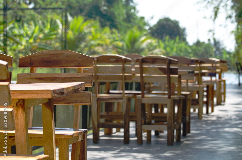Obraz premium Wooden long table and bench under tree shade. Picnic table with a view.