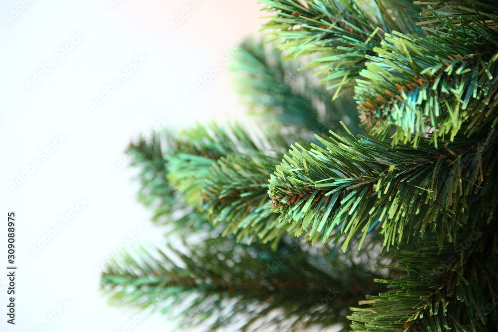 green branches of an artificial Christmas tree. Left place for text. artificial Christmas tree branches, selective focus