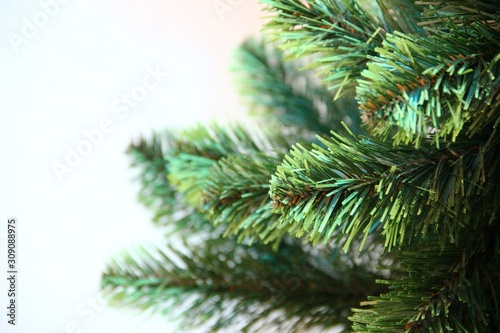 green branches of an artificial Christmas tree. Left place for text. artificial Christmas tree branches  selective focus