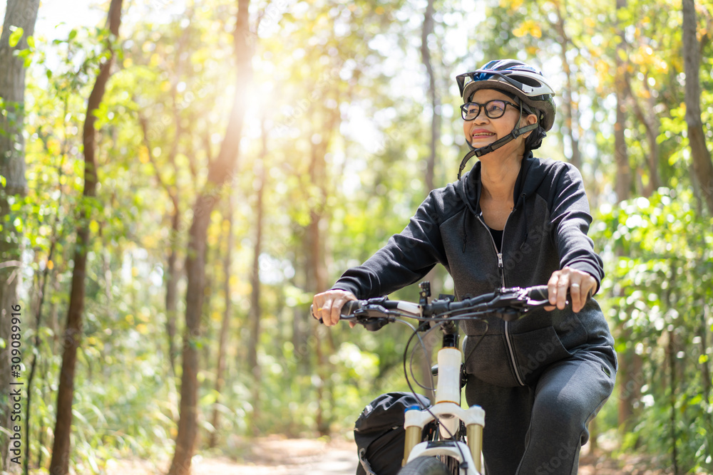 Fototapeta premium Senior asian woman riding bikes in park