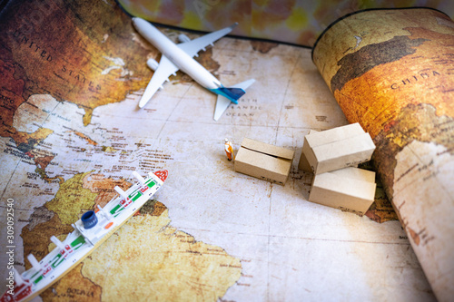 Miniature people: Worker and brown paper box on world map with airplane, ship using as background business shipping, rent container, worldwide transportation concept.