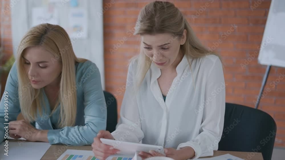 we won! two successful women of 35 years old read good news on a tablet. good job! 4k we won! two successful women of 35 years old read good news on a tablet. good job! 4k