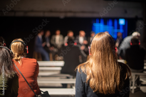 Woman with headphones on listening to a technology conference