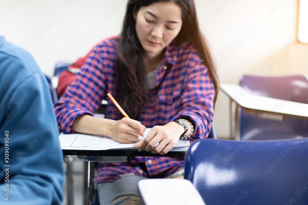 high school,university student study.hands holding pencil writing paper answer sheet.sitting lecture chair taking final exam attending in examination classroom.concept scholarship for education abroad high school,university student study.hands holding pencil writing paper answer sheet.sitting lecture chair taking final exam attending in examination classroom.concept scholarship for education abroad