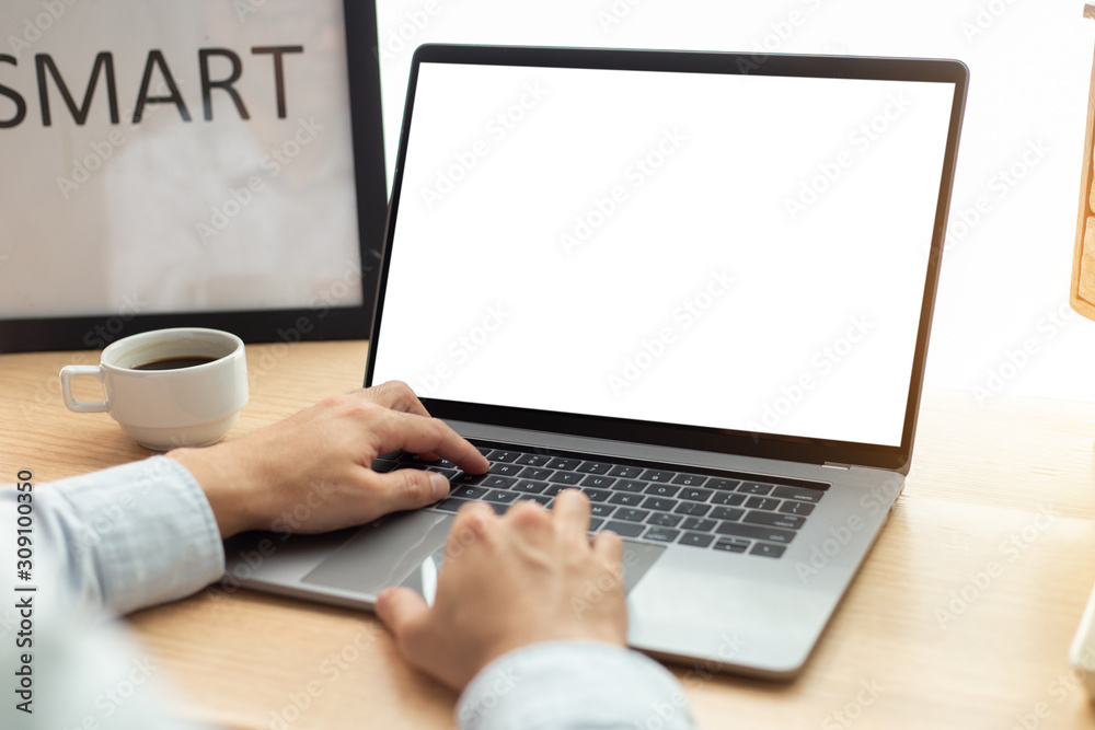 mockup image blank screen computer with blank white background for advertising text,hand man using laptop contact business search information on desk at home office.marketing and creative design mockup image blank screen computer with blank white background for advertising text,hand man using laptop contact business search information on desk at home office.marketing and creative design
