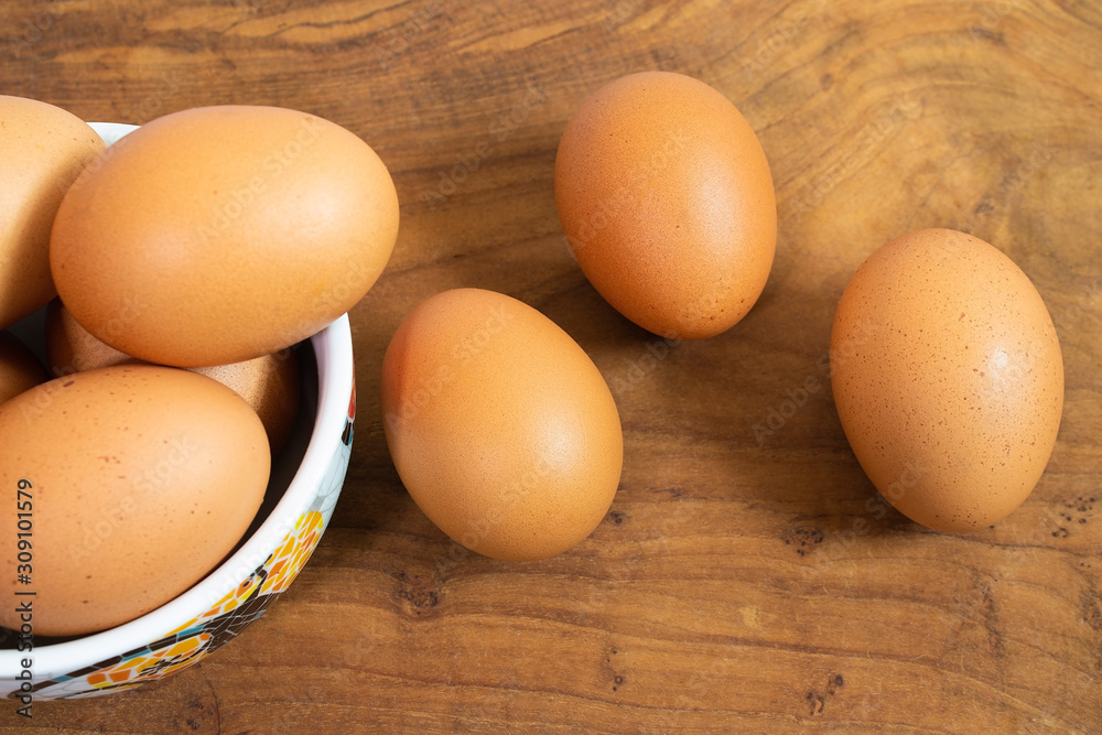 There are many fresh eggs in the picture, placed in cups and on wooden floors. There are many fresh eggs in the picture, placed in cups and on wooden floors.