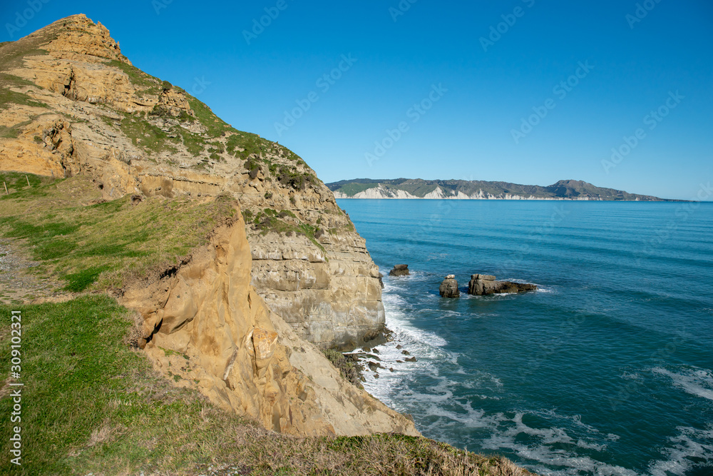 Looking down to the ocean from steep tall rugged dramatic cliffs at the coast