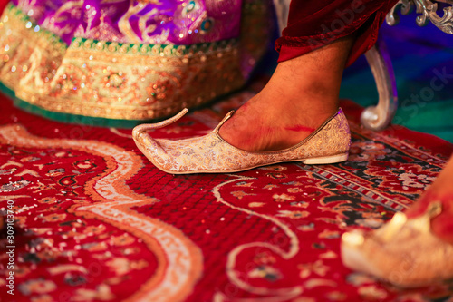 Traditional indian wedding ceremony : Groom puts on  wedding shoes photo