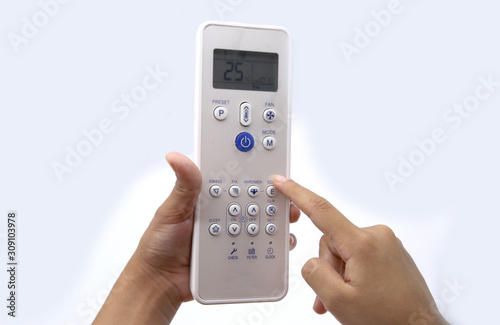 Hand holding air conditioner remote control on white background
