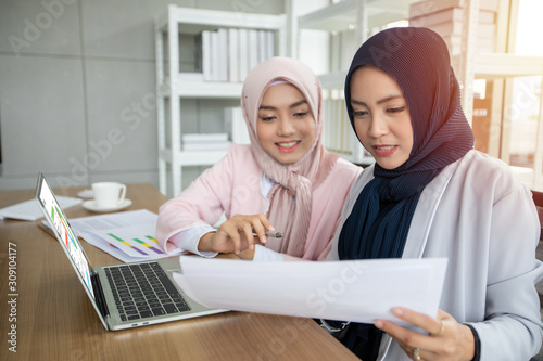 Muslim business woman in traditional clothing working and discussing at meeting in office.