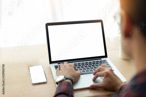 mockup image blank screen computer,cell phone with white background for advertising text,hand man using laptop texting mobile contact business search information on desk in office.marketing and design