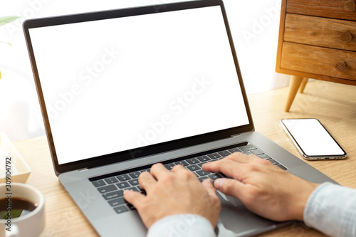 mockup image blank screen computer with blank white background for advertising text,hand man using laptop contact business search information on desk at home office.marketing and creative design