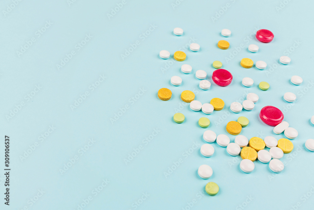 Colorful pills on a pastel blue background. Flat lay, top view, overhead, mockup, template. Pharmacy and medical concept