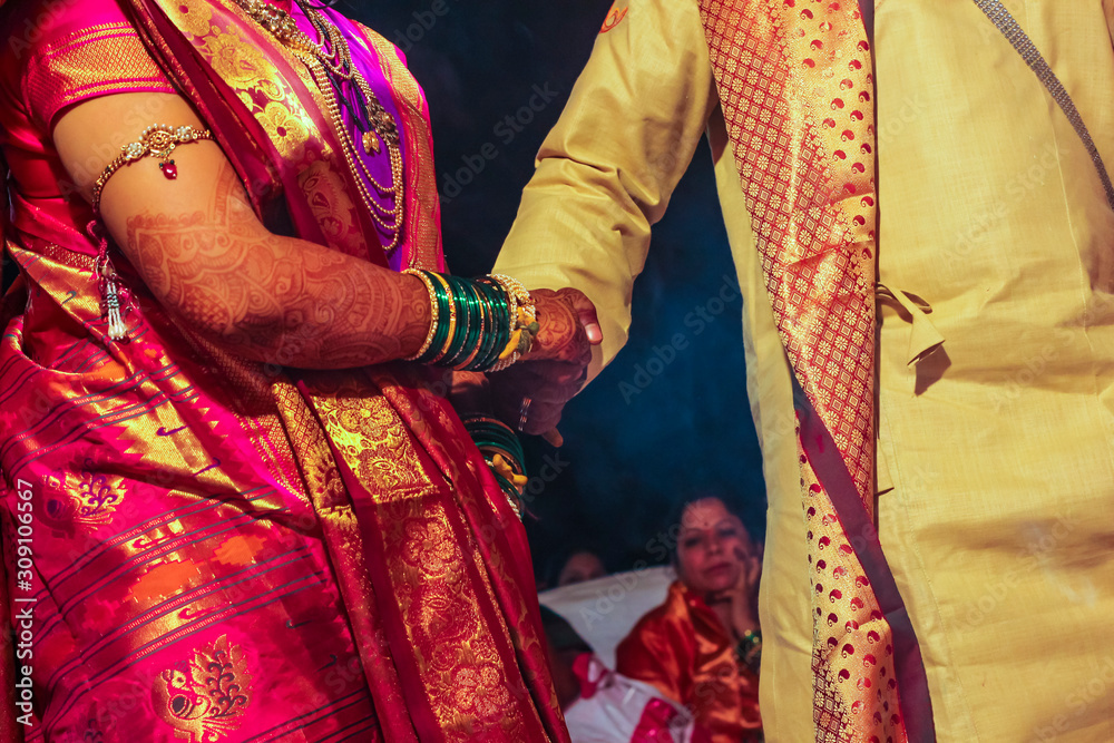 Traditional indian wedding ceremony, groom holding hand in bride hand