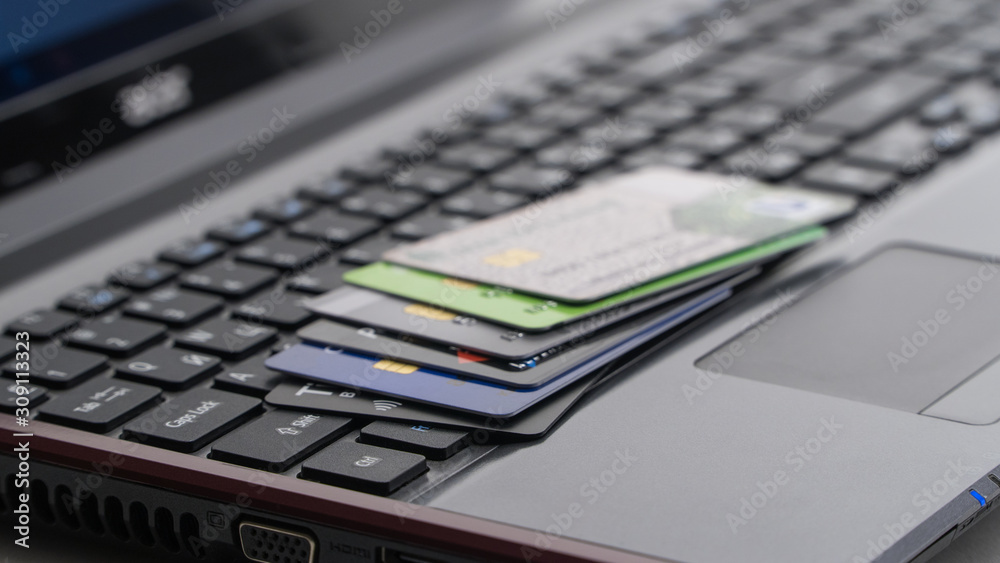 Credit cards on laptop keyboard. Concept of online shopping and E-commerce Credit cards on laptop keyboard. Concept of online shopping and E-commerce