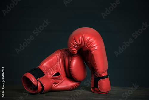 Pair of red boxing gloves on a black background. Copy space