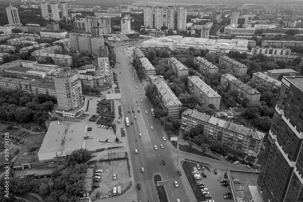 Black and white aerial view in the city with a large number of densely built houses and skyscrapers in the Novosibirsk with infrastructure, transport and traffic. Urban life an environmental problems.