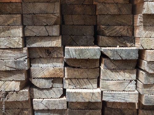 Piled wooden beams, piled lumber in the outdoor warehouse
