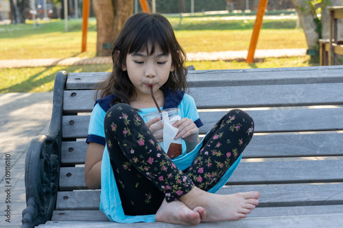 Portrait Asian little girl drink juice happy smile