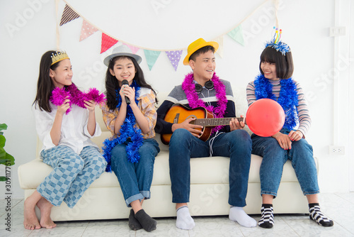 Group of Happy Asian teenager sing a song and playing guitar with friends in Party.