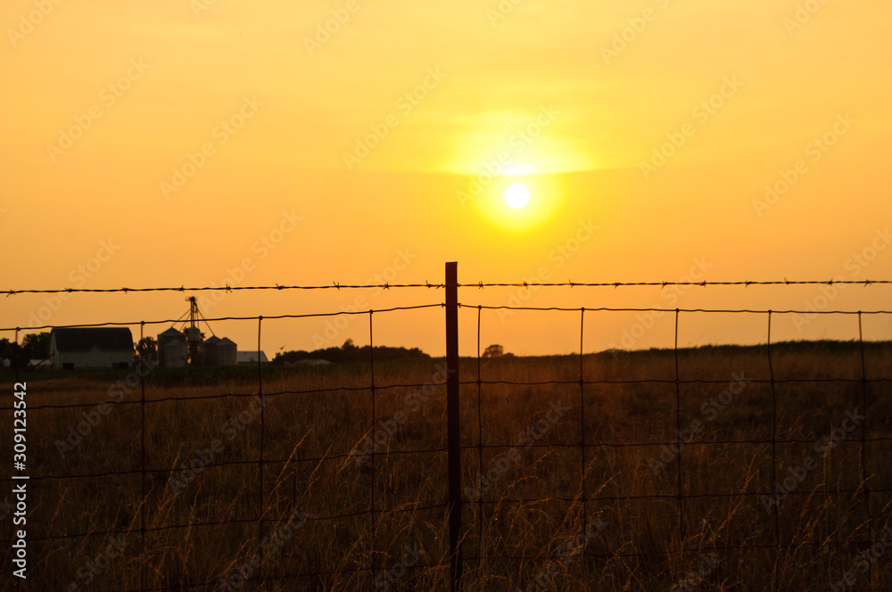 Fototapeta premium sunset through fence
