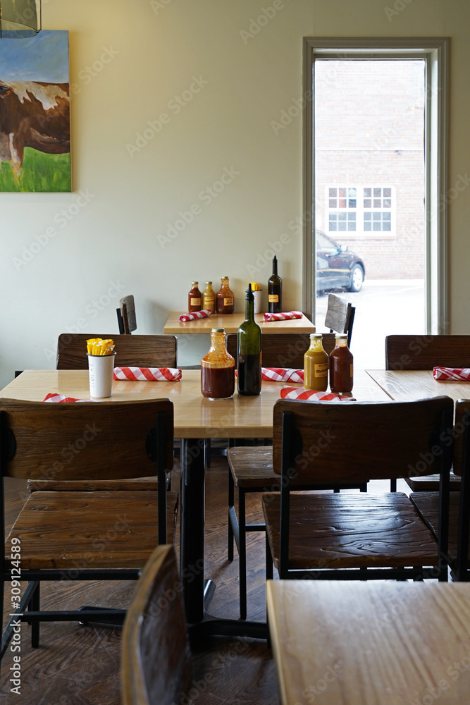 Restaurant table setting and arrangement, decorated with dipping sauce bottles and wooden furniture