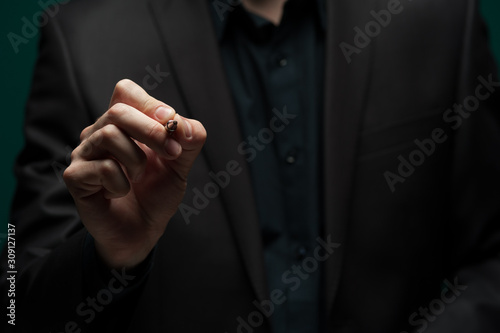 Man in a dark shirt and jacket holds ballpoint pen © pavel_shishkin