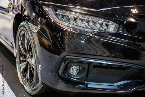 Close up of detail on one of the LED headlights modern and luxury black car. Select focus.