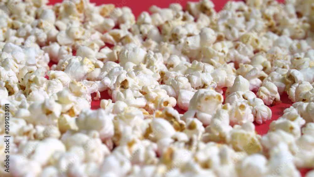 tracking slider shot of spread popcorn in focus on red backdrop 4K tracking slider shot of spread popcorn in focus on red backdrop 4K