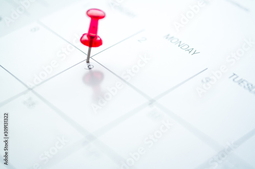 Red push pin on calendar 9th day of the month