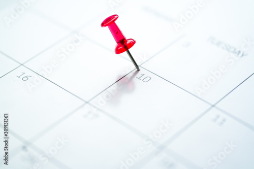 Red push pin on calendar 10th day of the month