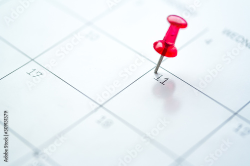 Red push pin on calendar 11th day of the month