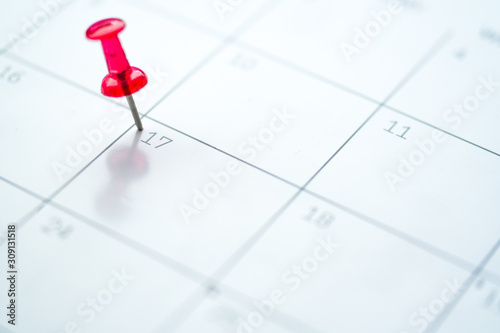 Red push pin on calendar 17th day of the month