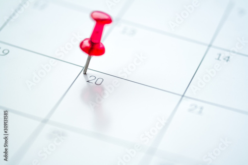 Red push pin on calendar 20th day of the month