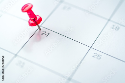 Red push pin on calendar 24th day of the month