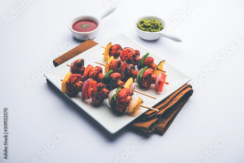 Barbecue or tandoori Mushroom Tikka, served in a plate with green chutney and ketchup. selective focus