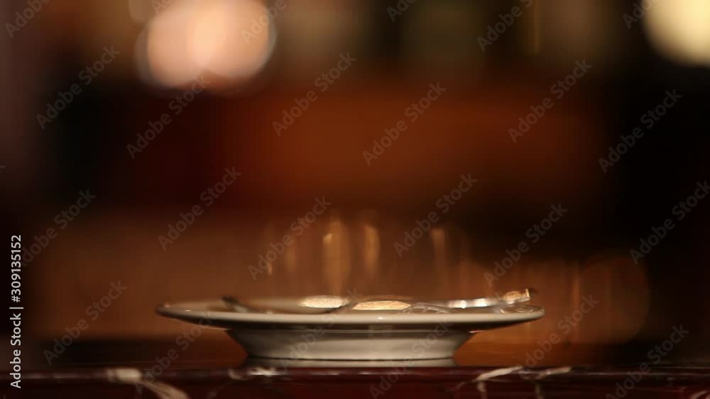 Close up of cup of cappuccino and a female hand in a restaurant on the background of lights Close up of cup of cappuccino and a female hand in a restaurant on the background of lights