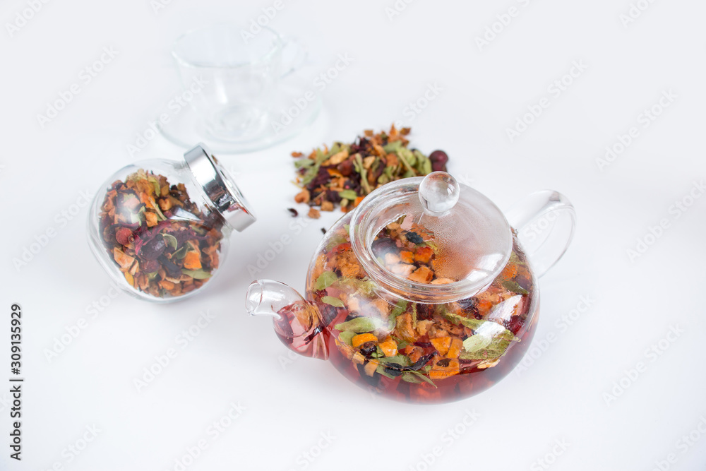 Fragrant fruit tea in a glass teapot on a dark wooden background. Fragrant fruit tea in a glass teapot on a dark wooden background.