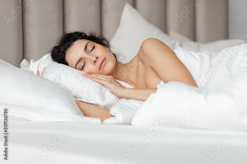 Beautiful  woman having  dreams in white bed  photo