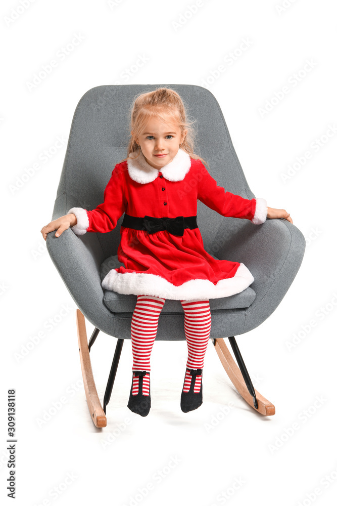 Cute little girl in Santa costume sitting on chair against white background Cute little girl in Santa costume sitting on chair against white background