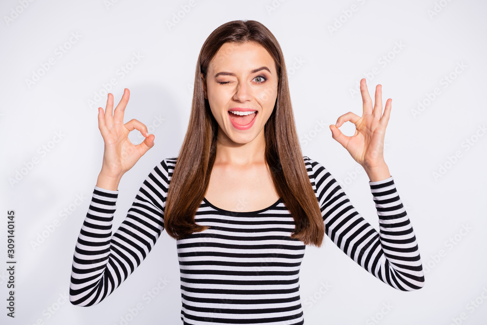 Portrait of cool woman showing okay sign winking wearing striped pullover isolated over white background Portrait of cool woman showing okay sign winking wearing striped pullover isolated over white background