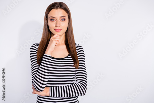 Portrait of charming woman touching her chin looking at camera wearing striped sweater isolated over white background