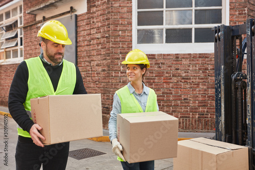 Zwei Logistik Arbeiter tragen zusammen Pakete photo